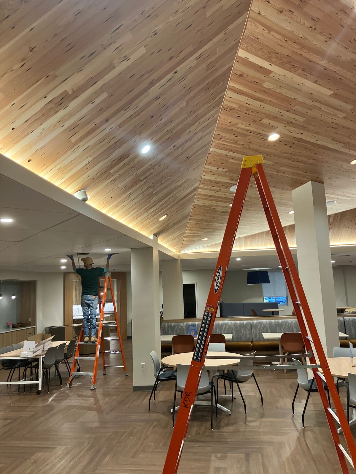 Wood-slat ceiling with recessed and cove accent lighting